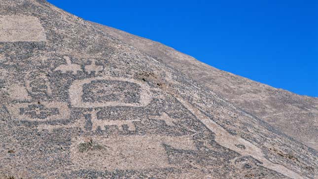 Una fotografía de una antigua obra de arte tallada en el desierto. 