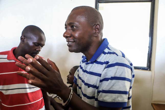 Self-proclaimed pastor Paul Nthenge Mackenzie gestures while talking to other defendants as he appears at Malindi Law Courts in Malindi on January 17, 2024. A Kenyan court on January 17, 2024 gave prosecutors two more weeks to conduct mental health assessments of a cult leader and 30 suspected accomplices before charging them with murder over the deaths of more than 400 followers. Paul Nthenge Mackenzie is alleged to have incited his acolytes to starve to death in order to “meet Jesus” in a case that shocked the world. 