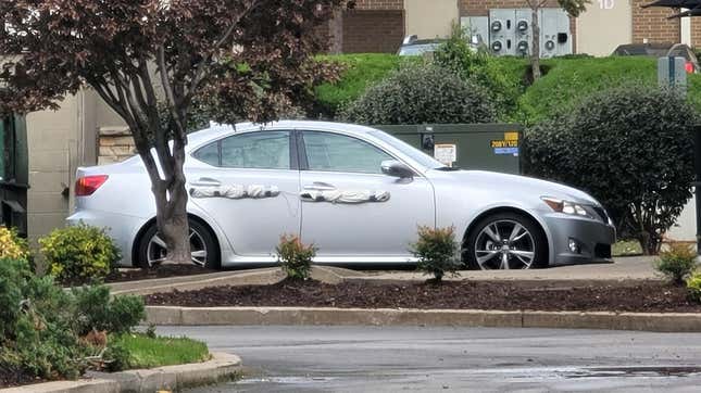 The homemade dent protector strapped to the side of a Lexus