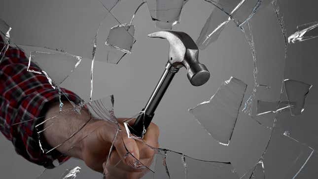 An image shows a man breaking glass with a hammer. 