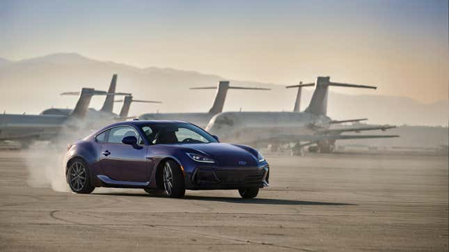 Une Subaru BRZ violette dérivant sur un aérodrome devant des avions géants