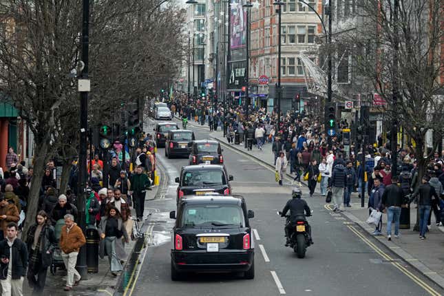 FILE - Shoppers walk along Oxford Street during the Boxing Day sales in London, Tuesday, Dec. 26, 2023. Inflation across the United Kingdom increased unexpectedly last month as a result of sharp hike in tobacco and alcohol prices. The Office for National Statistics said on Wednesday, Jan. 17, 2024, that inflation, as measured by (AP Photo/Kin Cheung, File )