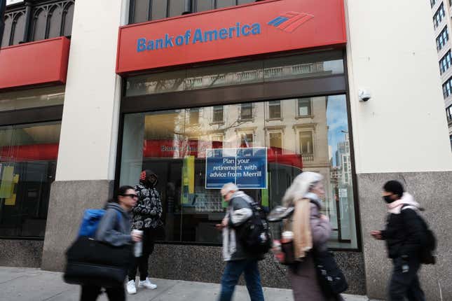 People dressed in winter clothes walk past a Bank of America branch in Manhattan.