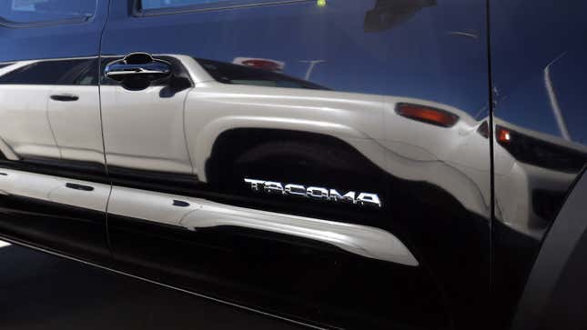 A photo of a Tacoma badge on a Toyota pickup truck. 