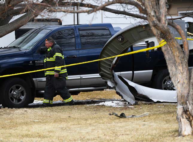 FILE - A North Metro firefighter walks past a large piece of a United airplane engine in the front yard of a home on Elmwood Street near E. 13th Avenue, Saturday, Feb. 20, 2021, in Broomfield, Colo. An engine on a United Airlines jet broke up over Denver in 2021 because of wear and tear on a fan blade that was not adequately inspected for signs of cracking, federal investigators said Friday, Sept. 8, 2023. (Andy Cross/The Denver Post via AP, File)