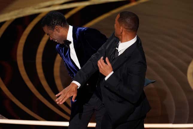 Will Smith, right, hits presenter Chris Rock on stage while presenting the award for best documentary feature at the Oscars on Sunday, March 27, 2022, at the Dolby Theatre in Los Angeles.