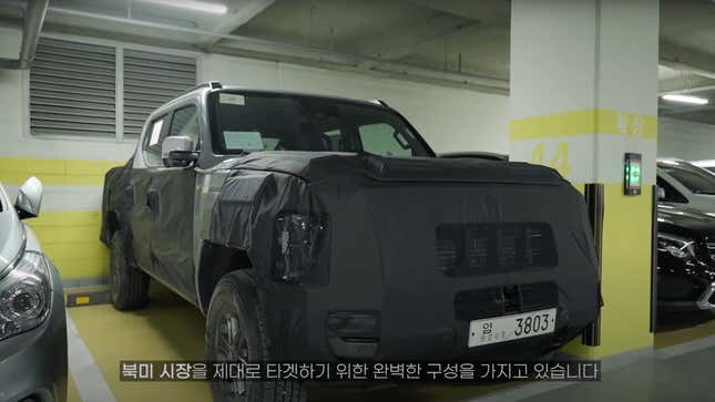 Spy shot of a camouflaged Kia Tasman pickup prototype