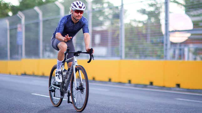 Una foto de Valtteri Bottas montando una bicicleta en una pista de carreras. 