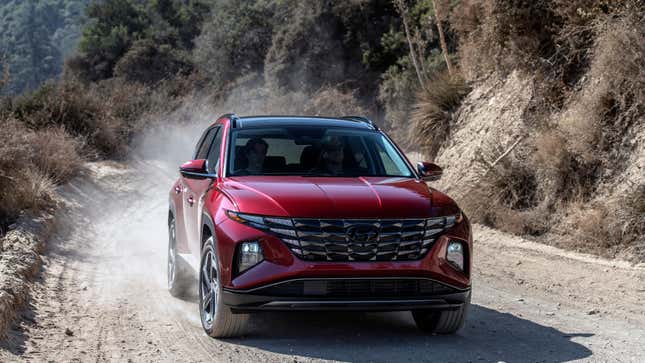 Un Hyundai Tucson rouge conduisant sur un chemin de terre