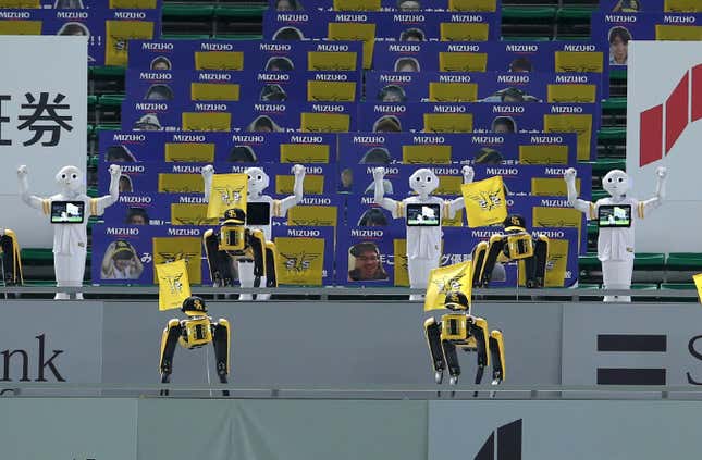 SoftBank Corp’s humanoid robots Pepper (white) and Boston Dynamics’ robots SPOT (yellow) dance and sing before the Nippon Professional Baseball league match between SoftBank Hawks and Rakuten Golden Eagles in Fukuoka on July 10, 2020.