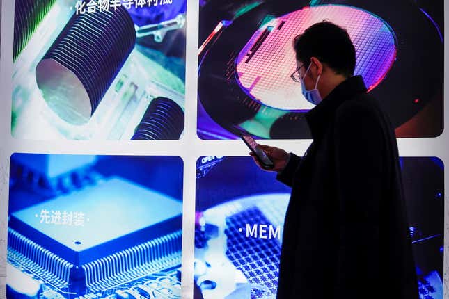 A man visits a display of semiconductor devices at semiconductor technology trade fair Semicon China, in Shanghai.