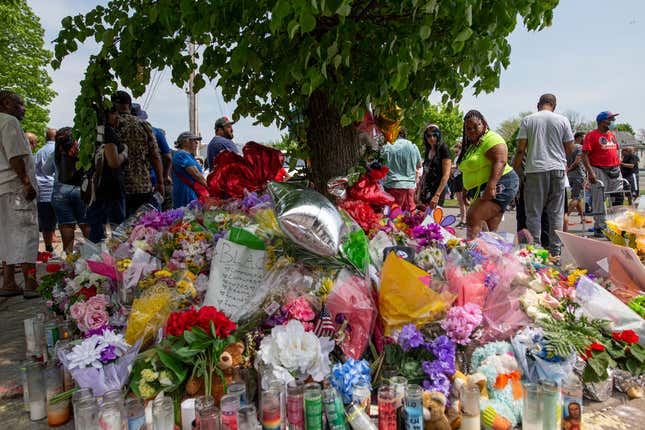 People walk by a memorial for the victims of the Buffalo supermarket shooting outside the Tops Friendly Market on Saturday, May 21, 2022, in Buffalo, N.Y. Tops was encouraging people to join its stores in a moment of silence to honor the shooting victims Saturday at 2:30 p.m., the approximate time of the attack a week earlier. Buffalo Mayor Byron Brown also called for 123 seconds of silence from 2:28 p.m. to 2:31 p.m., followed by the ringing of church bells 13 times throughout the city to honor the 10 people killed and three wounded.