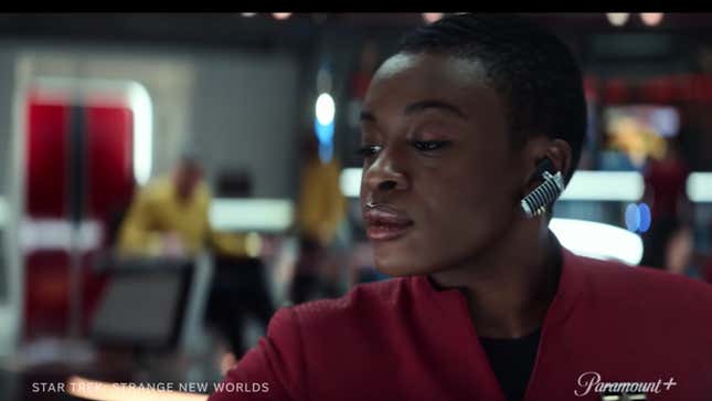 Cadet Uhura monitors the comms via a silver earpiece on the deck of the Enterprise.