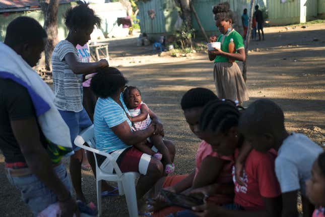 A child cries in her mother’s arms at the Lima batey in La Romana, Dominican Republic, Wednesday, Nov. 17, 2021. The bateyes formed around the sugar cane mills where cane workers, mainly Haitians, eventually established their immigrant communities.