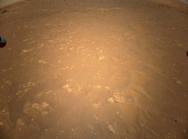 Una vista aérea de Marte capturada por Ingenuity el 25 de abril de 2021. Tomada desde una altura de 85 metros (279 pies), el helicóptero  logró ver el rover Perseverance abajo (muy arriba a la izquierda de la imagen). 