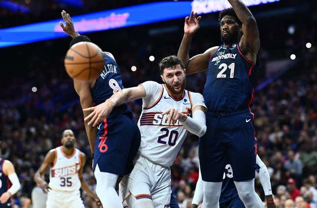 Nov 4, 2023; Philadelphia, Pennsylvania, USA; Phoenix Suns center Jusuf Nurkic (20) passes the ball between Philadelphia 76ers center Joel Embiid (21) and guard De&#39;Anthony Melton (8) in the first quarter at Wells Fargo Center.