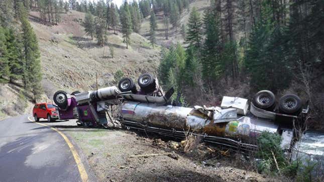 A photo of a crashed tanker near a river. 