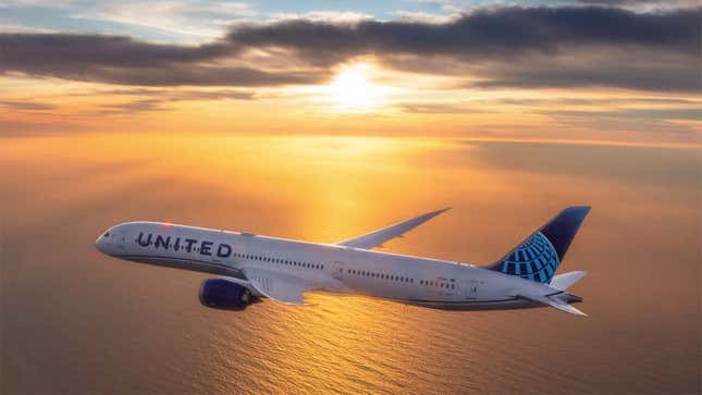 A photo of a United Airlines plane flying over the ocean. 