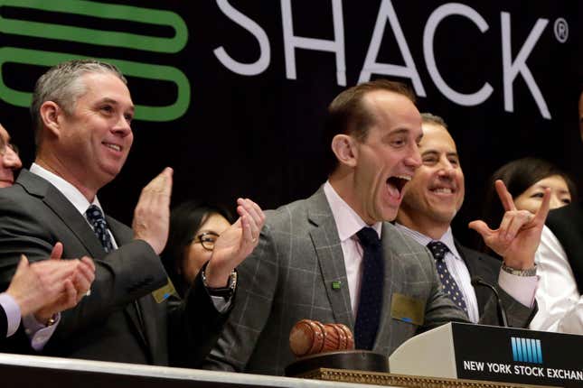 FILE - Shake Shack CEO Randy Garutti, center, joined by company CFO Jeff Utz, left, and founder Danny Meyer, celebrate during opening bell ceremonies at the New York Stock Exchange, Jan. 14, 2016. Garutti will retire from the popular burger and milkshake chain next year once a successor is chosen. The company plans to keep Garutti as an advisor through the end of 2024 to help the selected CEO with the transition process. (AP Photo/Richard Drew, file)