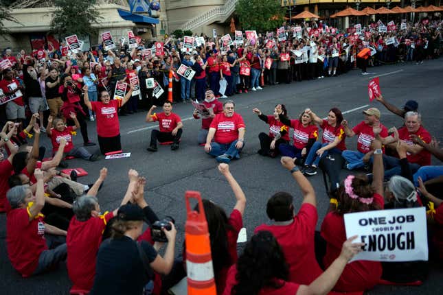 Members of the Culinary Workers Union block traffic along the Strip, Wednesday, Oct. 25, 2023, in Las Vegas. Thousands of hotel workers fighting for new union contracts rallied Wednesday night on the Las Vegas Strip, where rush-hour traffic was disrupted when some members blocked the road before being detained by police. (AP Photo/John Locher)