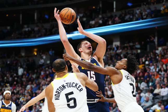 Oct 30, 2023; Denver, Colorado, USA; Utah Jazz guard Collin Sexton (2) fouls Denver Nuggets center Nikola Jokic (15) in the second half at Ball Arena.