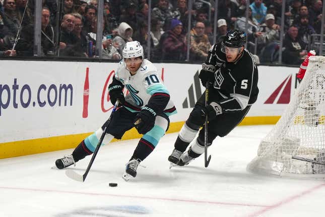 Dec 20, 2023; Los Angeles, California, USA; Seattle Kraken center Matty Beniers (10) and LA Kings defenseman Andreas Englund (5) battle for the puck in the first period at Crypto.com Arena.