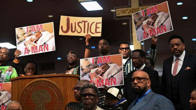 People hold signs as they attend a news conference for Tyre Nichols at Mason Temple on January 31, 2023 in Memphis, Tennessee.
