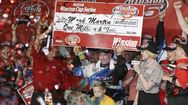 A photo of race driver Mark Martin holding a large check. 