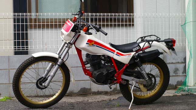 A photo of a white and red Honda TRL 200 motorbike. 