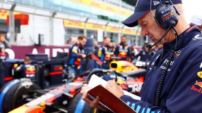 A photo of Adrian Newey writing in a note book. 