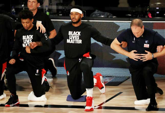 Carmelo Anthony of the Portland Trail Blazers kneels with teammates and coaches during the national anthem before the game against the Memphis Grizzlies at The Arena at ESPN Wide World Of Sports Complex on July 31, 2020 in Lake Buena Vista, Florida.