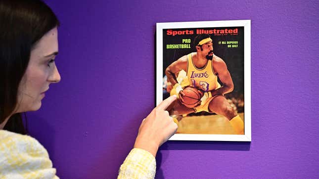 Rose Lobelson, Communications Associate at Sotheby's, points to an image of the Sports Illustrated cover of Wilt Chamberlain in his 'Championship Clinching' 1972 NBA Final jersey, with bandaged-hands after he broke a hand.