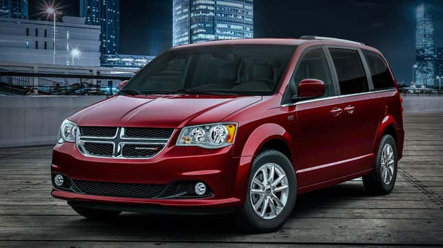 A red dodge grand caravan parked in front of a cityscape