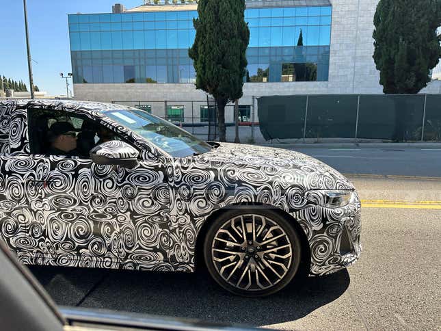 Close-up view of a camouflaged next-gen Audi S5 Sportback's front wheel