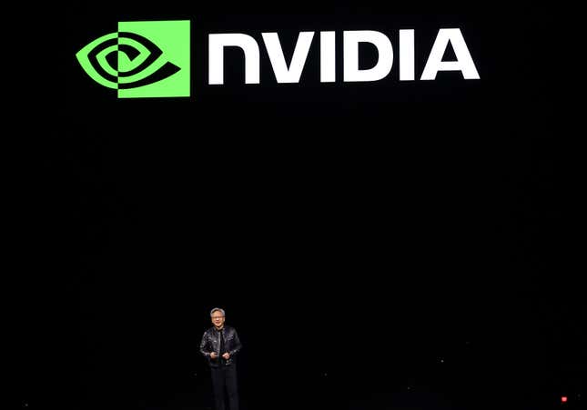 jensen huang standing at the bottom of the photo in front of a big black backdrop and the nvidia logo above him