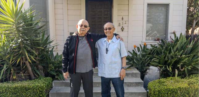 Lloyd Dong Jr. and Ron Dong stand in front of their childhood home. 