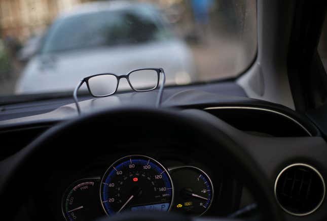 A pair of eyeglasses resting on the dashboard of a car