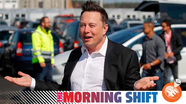 A photo of Elon Musk shrugging at an event in Germany. 