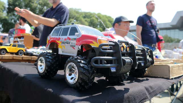 A photo of two toy monster trucks on a stall. 