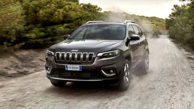 A dark gray cherokee driving on dirt