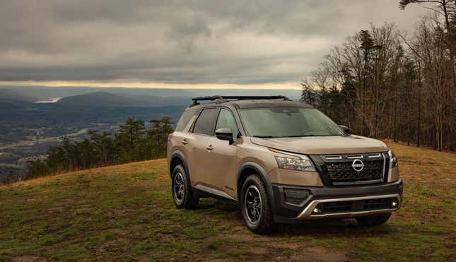 Bronze SUV parked on a grassy hillside.