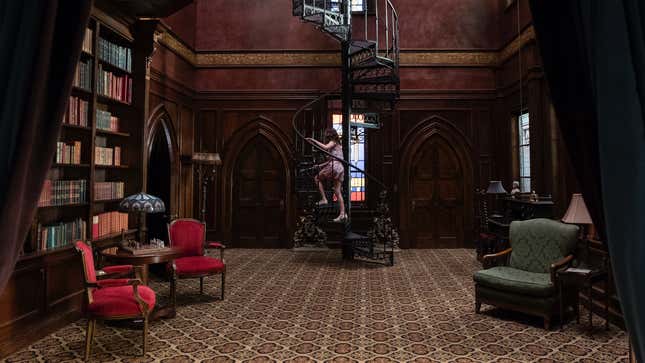 A small girl climbs a spiral staircase in a large library in Netflix's Haunting of Hill House.