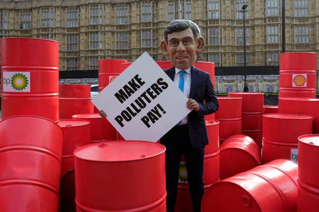 Oxfam&#39;s Rishi Sunak &#39;big head&#39; protests outside the Parliament in London, Tuesday, Sept. 19, 2023. On the eve of the UN Climate Ambition Summit, Oxfam&#39;s Rishi Sunak &#39;big head&#39; staged a protest on top of a giant oil barrel, amongst dozens of real oil drums, supporting the Make Polluters Pay campaign. Calling for oil and gas giants, such as BP and Shell, to pay more tax to raise critical funds to help communities devastated by climate change. (AP Photo/Kin Cheung)