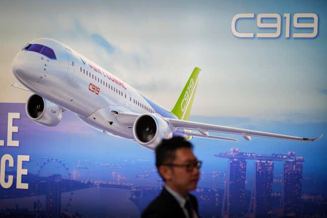 A visitor walks in front of a poster of China&#39;s Comac C919 aircraft during the first day of Singapore Airshow in Singapore, Tuesday, Feb. 20, 2024. The Singapore Airshow, Asia&#39;s largest, kicked off Tuesday with an array of aerial displays including some by China&#39;s COMAC C919 narrow-body airliner.(AP Photo/Vincent Thian)