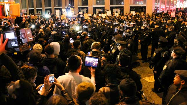 Police, dressed in riot gear, attempt to stop the protesters headed toward Rockefeller Center.