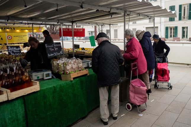 FILE - People shop at an open air market in Fontainebleau, south of Paris, France, on Feb. 2, 2024. The French government has announced a new rule that will require stores to tell customers when a product becomes smaller but its price stays the same or increases. This practice, known as shrinkflation, will need to be clearly communicated to shoppers under the rule that takes effect on July 1. The common but often-criticized practice has become an international phenomenon and buzzword. Consumer watchdogs have welcomed the new rule. (AP Photo/Thibault Camus, File)