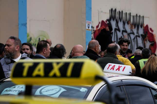 Taxi drivers gather during their rally in Athens, Greece, Tuesday, Feb. 27, 2024. Τaxi drivers in the Greek capital began a 48-hour strike Tuesday, with the second day timed to coincide with a nationwide strike by public and some private sector workers that is expected to disrupt public transport, ground some flights and leave ferries tied up in port. (AP Photo/Thanassis Stavrakis)