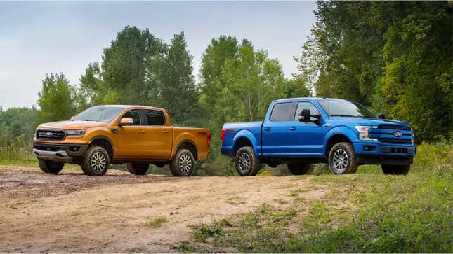 A photo of two Ford pickup trucks on a dirt road. 