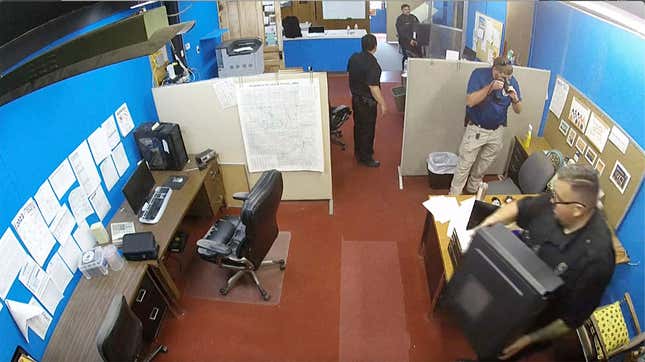 FILE - This image made from surveillance video provided by the Marion County Record shows members of the Marion, Kan., Police Department confiscating computers and cellphones from the publisher and staff of the Marion County Record, Aug. 11, 2023, in Marion, Kan. The police chief who led the August raid on the small weekly newspaper in central Kansas has resigned, just days after he was suspended from his post, a City Council member confirmed Monday, Oct. 2, 2023. (Marion County Record via AP, File)