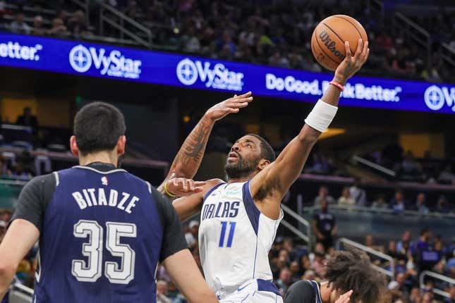 Nov 6, 2023; Orlando, Florida, USA; Dallas Mavericks guard Kyrie Irving (11) drives to the basket against Orlando Magic center Goga Bitadze (35) during the first quarter at Amway Center.